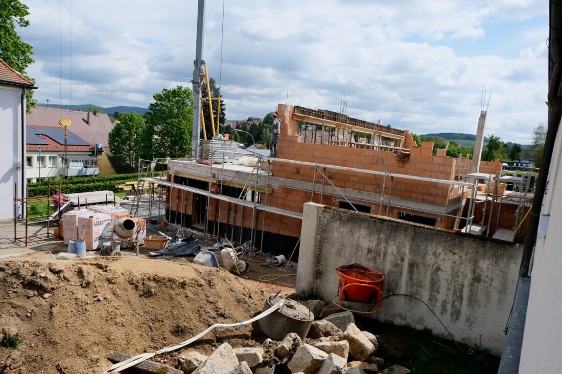 Floß. Die Erweiterung und Sanierung des katholischen Kindergartens St. Johannes Maria Vianney kommt gut voran. Ein Kran prägt den Pfarrgarten. Fertigstellung ist für Dezember geplant, getragen vom ökumenischen Miteinander.