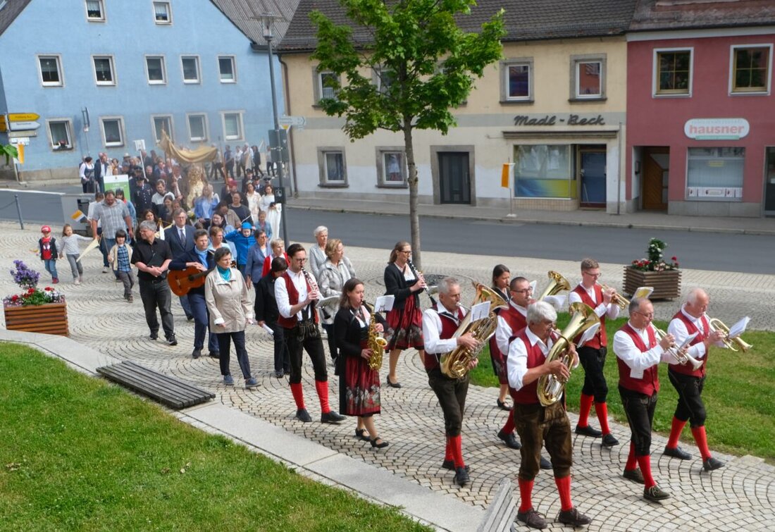 Floß. Die Pfarrgemeinde St. Johannes der Täufer feierte Fronleichnam mit Eucharistie und Prozession. Ab 8.25 Uhr zog der Kirchenzug los: Musik, Fahnen und Blumenteppich am Marktplatz, Abschluss und Segen an der Pfarrkirche.
