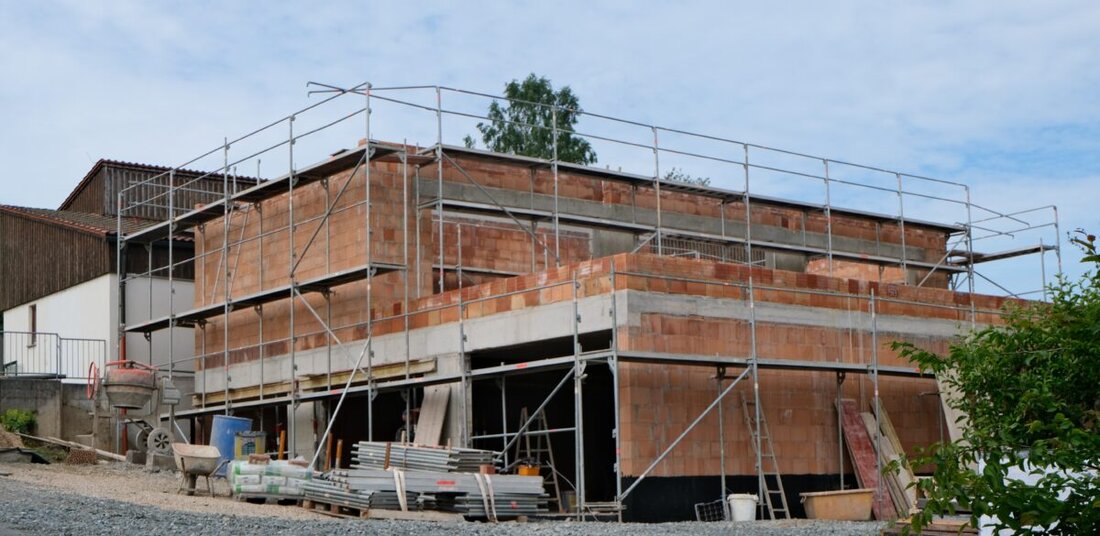 Floß. Die Erweiterung des Kindergartens St. Johannes Maria Vianney ist die derzeit größte Baustelle im Markt; der Rohbau steht, der Dachstuhl folgt in Kürze. Pfarrer Früchtl hofft auf Einzug heuer; Kinder sind im Pfarrheim.