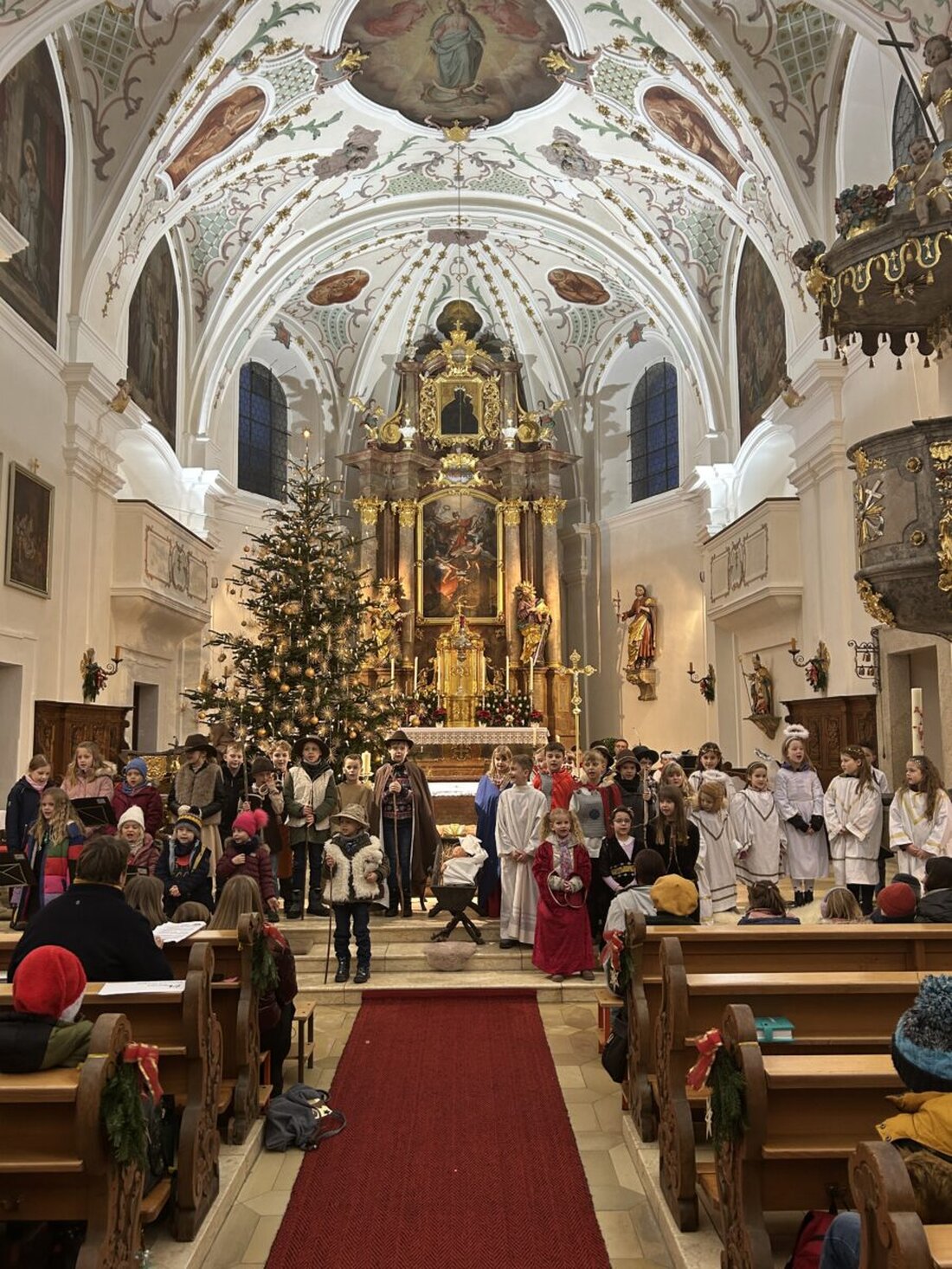 Neustadt/WN – Die diesjährige Kinderchristmette in der Stadtpfarrkirche St. Georg war ein voller Erfolg und lockte zahlreiche Familien in die prall gefüllte Kirche. Über 50 Kinder gestalteten ein liebevoll einstudiertes Krippenspiel, das die Weihnachtsgeschichte eindrucksvoll und lebendig auf die Bühne brachte.