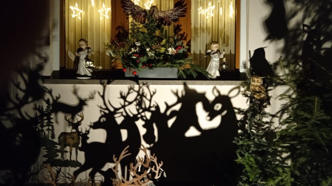 Floß. Christina Kreuzer gestaltet im elterlichen Garten mit Licht und Schatten eine weihnachtliche Waldszene mit Hirschen, Rehen, Füchsen, Hasen und Eulen. Engel und Sternenvorhang stiften Frieden und ehren ihre Eltern.
