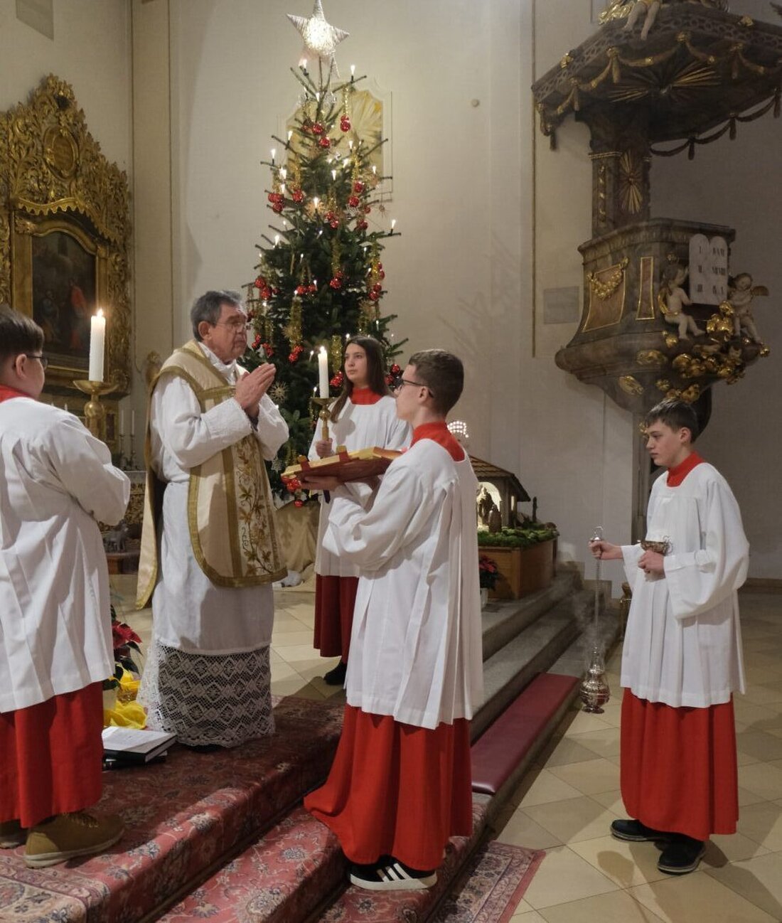 Floß. Pfarrer Max Früchtl dankt beim Fest der Heiligen Drei Könige allen Mitwirkenden. Er segnet sie, würdigt Sternsinger mit 7.640 Euro Spenden und lobt Kirchenmusik sowie Dienste von Mesnern und Ministranten.