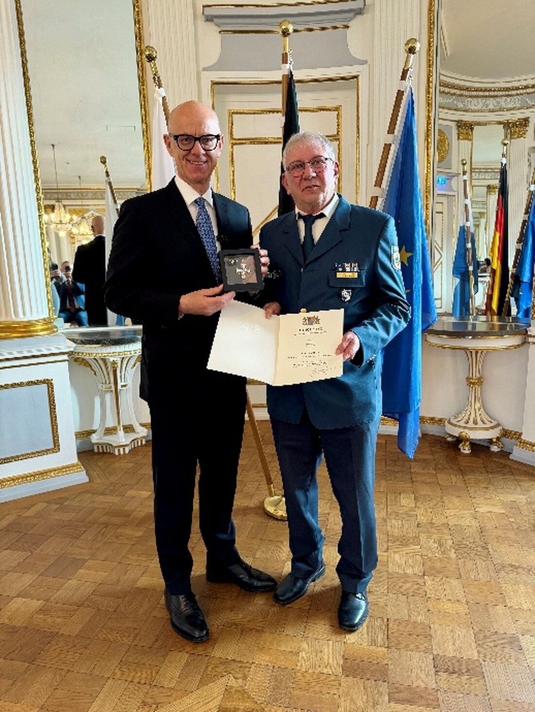 Regensburg. Regierungspräsident Walter Jonas ehrt Walter Schuster mit dem Steckkreuz des THW. Der Sulzbach-Rosenberger prägt seit 1997 die Rettungshundearbeit; heuer nur zwei Ehrungen unter 16.000 Ehrenamtlichen.